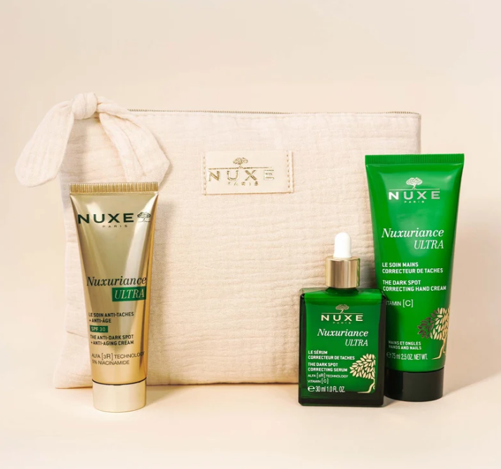 Comprar NUXE en Farmàcia Central Andorra. Trío Antimanchas & Antiedad Rostro & Manos.  Revela un tono más uniforme y una piel visiblemente más lisa y firme gracias a los cuidados expertos reunidos en este neceser antimanchas & antiedad. Incluye también una crema de manos que difumina las manchas, nutre y suaviza la piel. Tu neceser contiene: - Tratamiento Antimanchas + Antiedad SPF 30 - Corrige las manchas, previene su aparición y actúa sobre arrugas, firmeza y luminosidad. - Sérum Corrector de Manchas - Con TECNOLOGÍA ALFA [3R] y Vitamina C para reducir visiblemente tamaño, apariencia y número de manchas. - Crema de Manos Correctora de Manchas - Nutre sin acabado graso y reduce la apariencia de manchas. - Neceser beige de algodón - Un accesorio elegante para guardar tus cuidados favoritos.